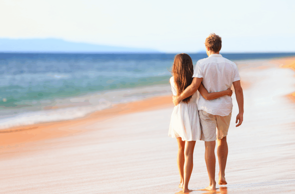 Newlyweds walk along the beach on honeymoon in riviera maya
