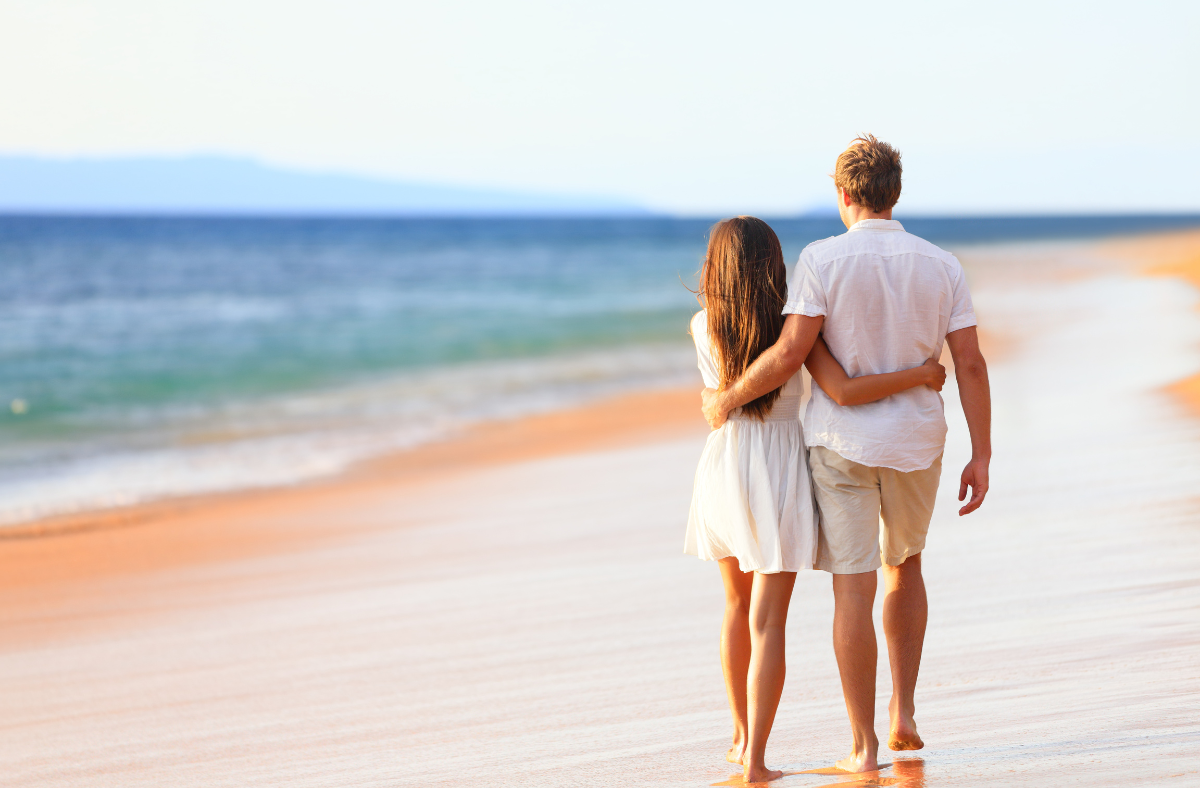 Newlyweds walk along the beach on honeymoon in riviera maya